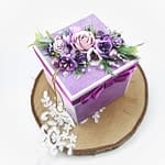 Fioletowy exploding box na urodziny. Ręcznie robiony box z bukietem kwiatów w środku. Ręcznie robiony prezent urodzinowy.