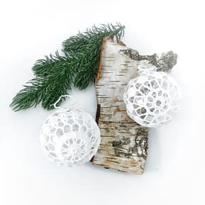 Wykonane na szydełku bombki z kordonka to oryginalna ozdoba bożonarodzeniowego drzewka. Białe, koronkowe bombki pięknie prezentują się na choince.