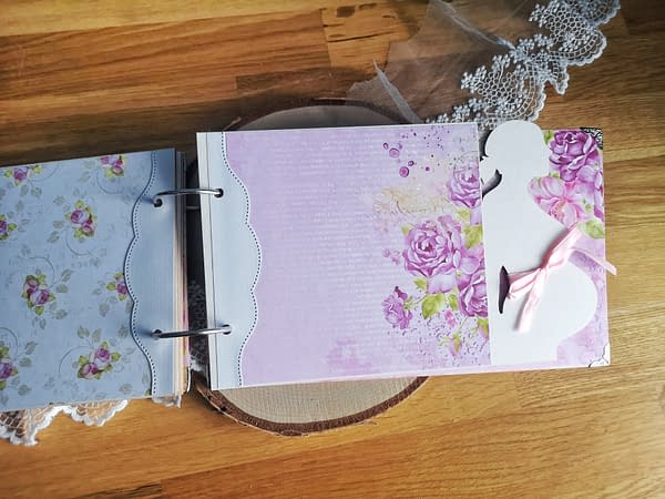 Album ciążowy ozdobiony techniką scrapbooking. Strony oklejone różowymi oraz kremowymi papierami w kwiaty. Idealny prezent dla przyszłej mamy spodziewającej się dziewczynki.