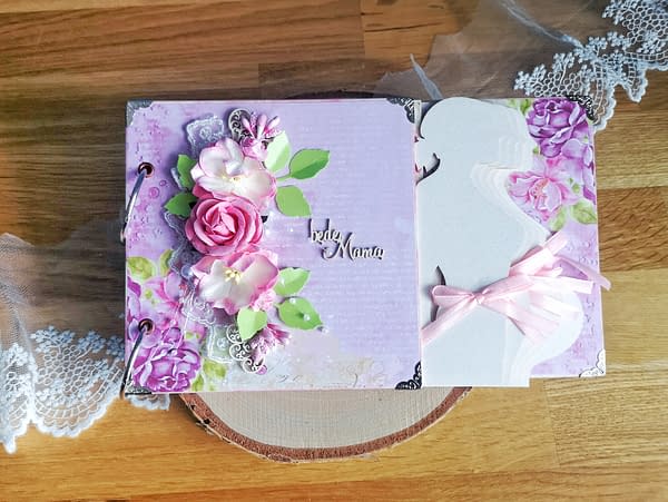 Różowy album ciążowy ozdobiony techniką scrapbooking. Strony oklejone różowymi oraz kremowymi papierami w kwiaty. Idealny prezent dla przyszłej mamy spodziewającej się dziewczynki.